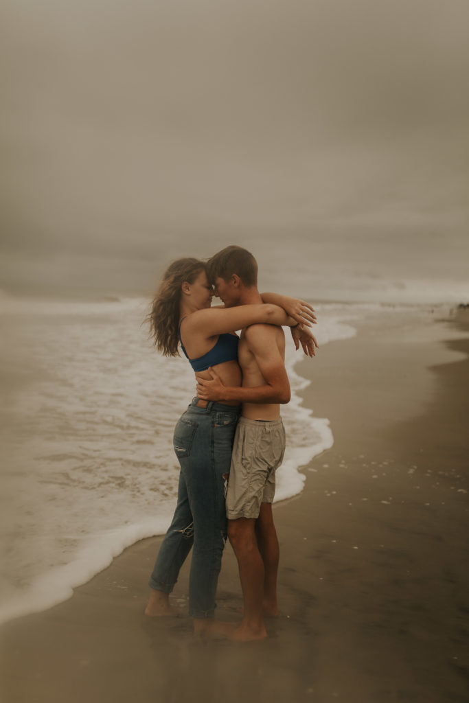 A florida couple kissing on the beach at new smyrna beach during their engagement photoshoot