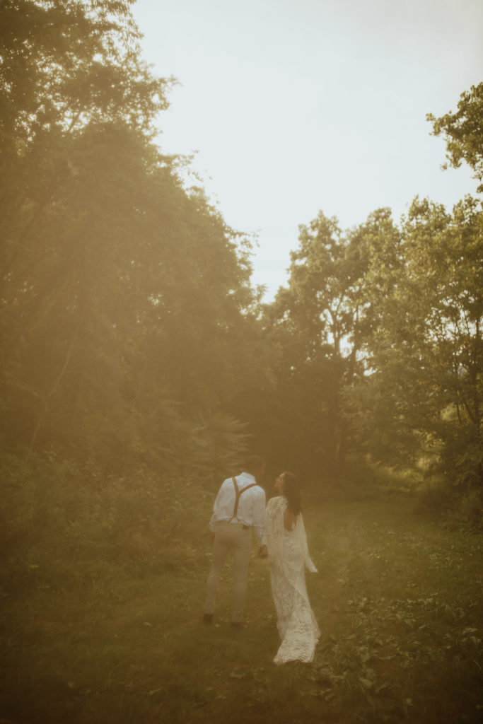 A couple eloping in front of the central Pennsylvania mountains at sunset with their guitar