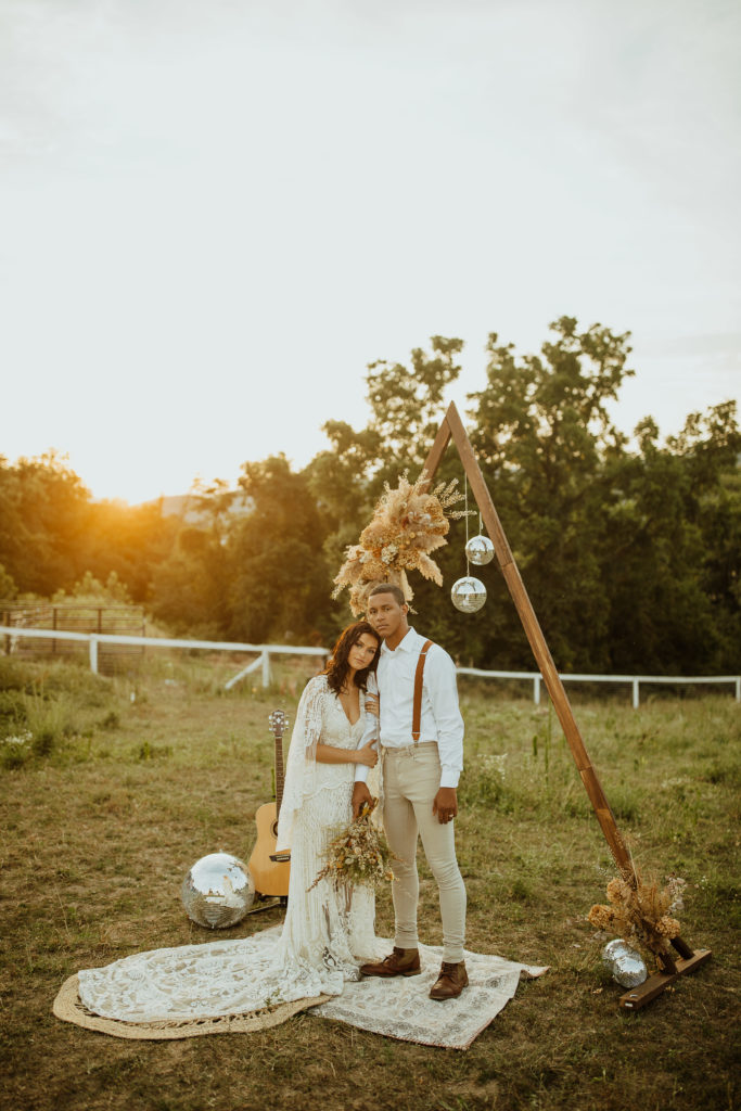 A couple eloping by the mountains in central Pennsylvania with an arch playing the guitar 