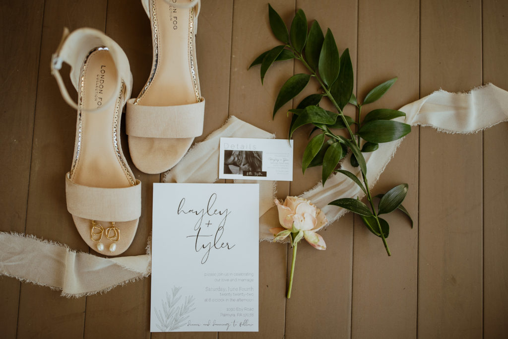 Wedding details of the invitation suite, wedding shoes, and rings