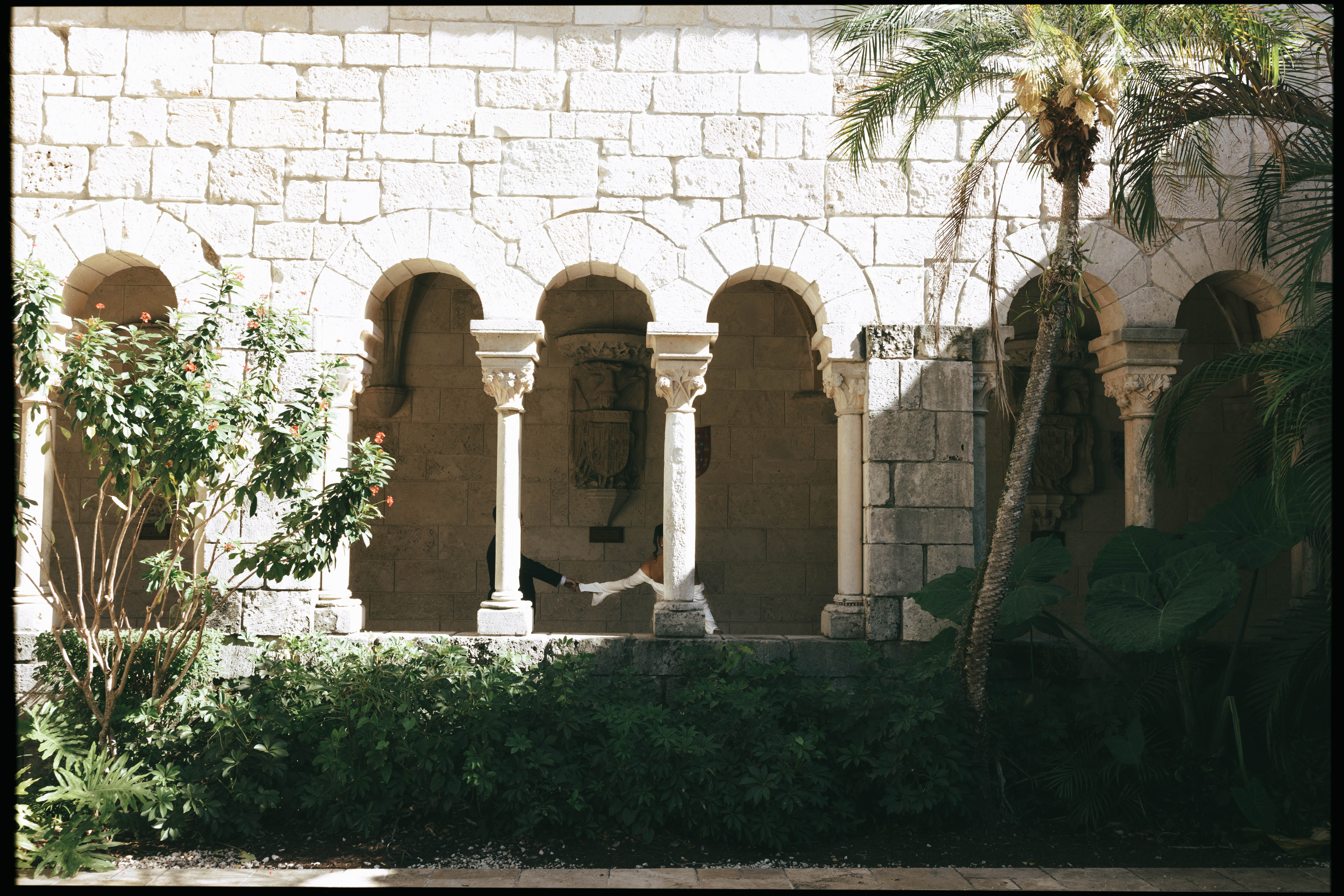 Elegant wedding couple photographed in front of European-style stone walls at The Spanish Monastery.