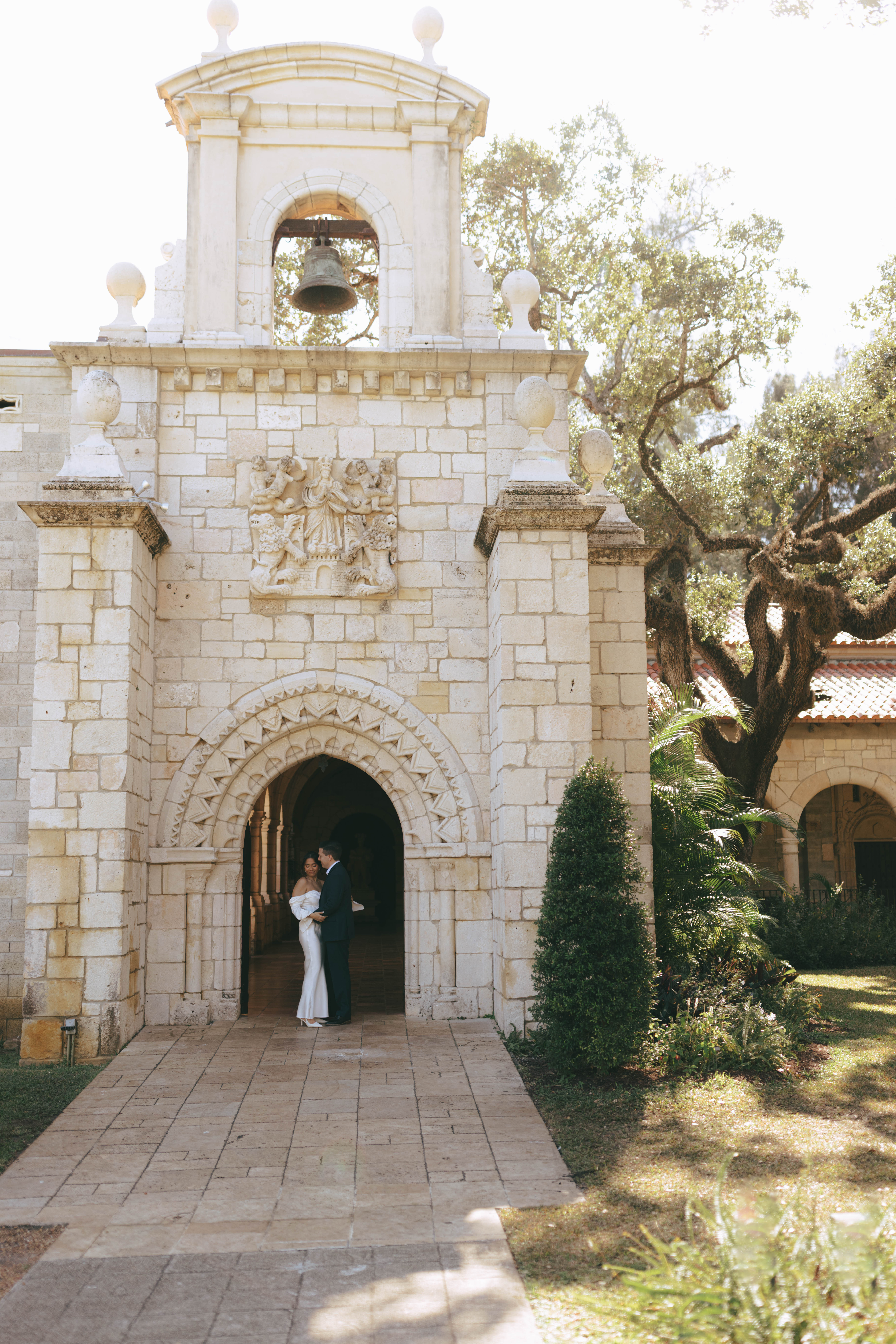 Elegant wedding couple photographed in front of European-style stone walls at The Spanish Monastery.