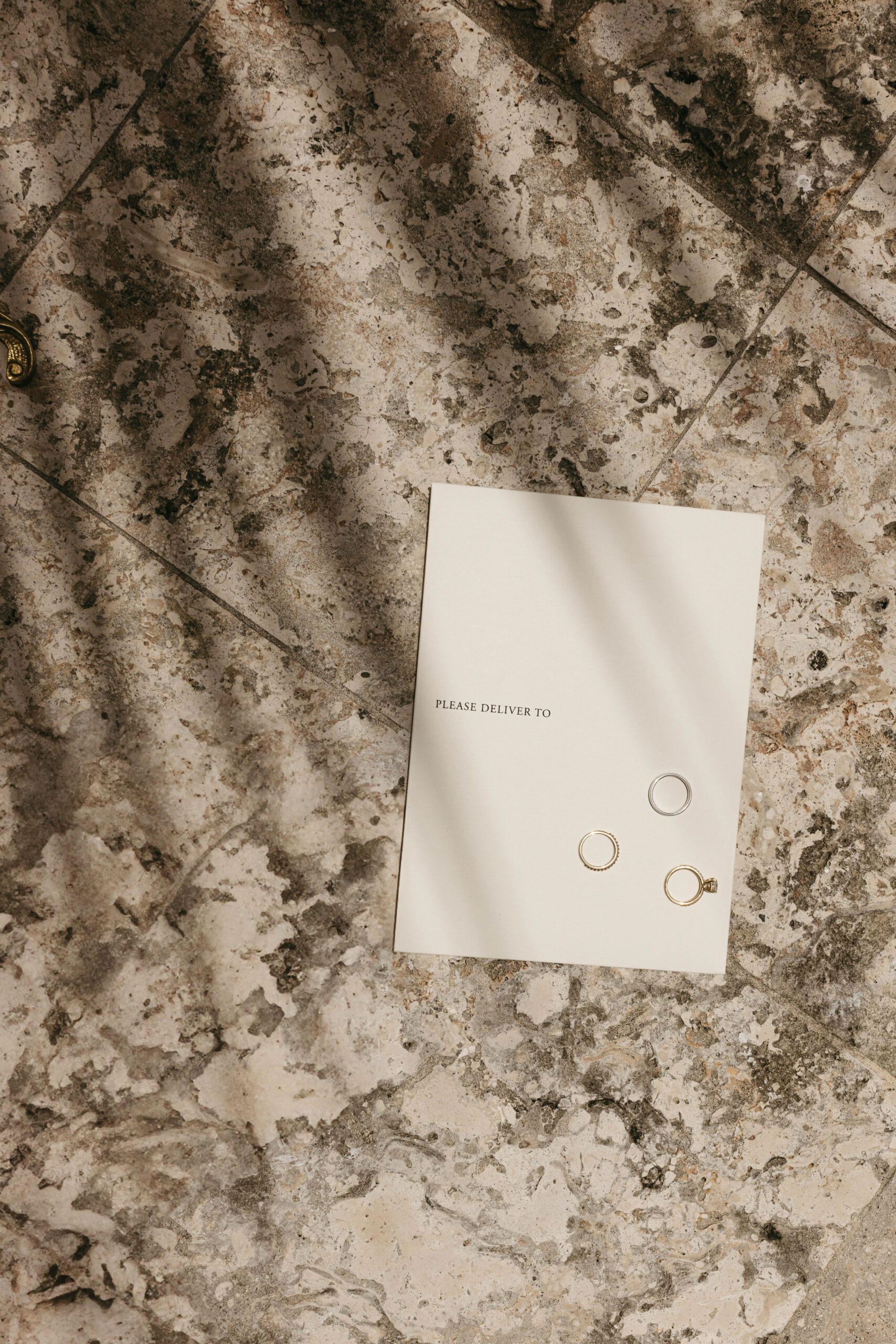 Editorial South Florida wedding details flat lay with invitation suite, rings, and floral accents