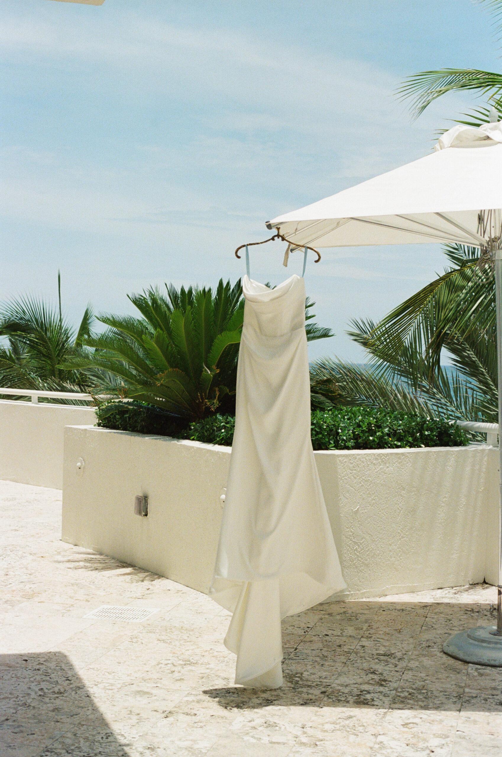 Editorial South Florida wedding details flat lay with invitation suite, rings, and floral accents